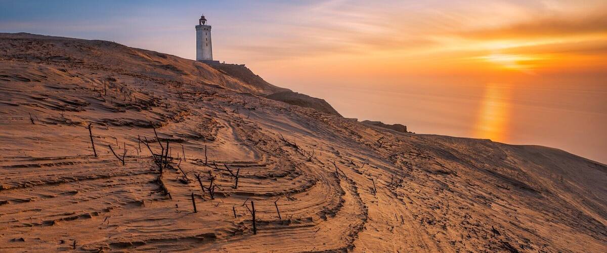 An old lighthouse build in 1900 and placed on a cliff 60m above sea level.
Over time, the lighthouse has been swallowed by the sand dunes, which make a a very unique place to visit. This is a must to visit if you're in Denmark/Jutland.
There is a parking lot 1 km- ish from the lighthouse and a great walk path right from the parking lot to the lighthouse.