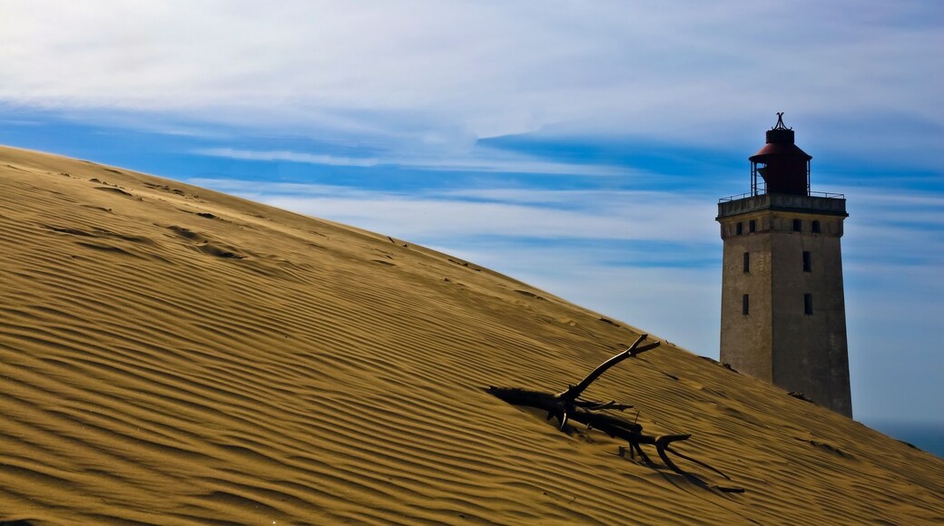 Welcome to Denmark !!
This is Rubjerg Knudle Lighthouse near Aalborg on the Northwestern coast of the North Sea. It was first lite in 1900 and was functional to 1969.
The interior (somewhat unsafe brick and stairs) will be closed in a year and the entire structure is expected to be swallowed by the sea within 10 years. It was officially closed as a Lighthouse in 1969 and later in 1980 re opened as a giant Kaleidoscope.
The 3 supporting houses next to the lighthouse have already been destroyed by the encroaching sea and deepening sand dunes.
This will be a casually of global warming and the encroachment of the sea.