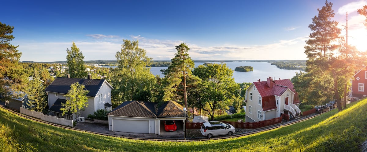 A lakeside residential area with houses, a train track, and a clear view of the lake.