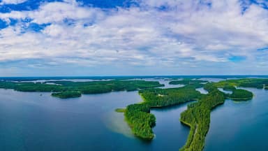 An aerial view of a large lake surrounded by numerous small islands and dense forests.