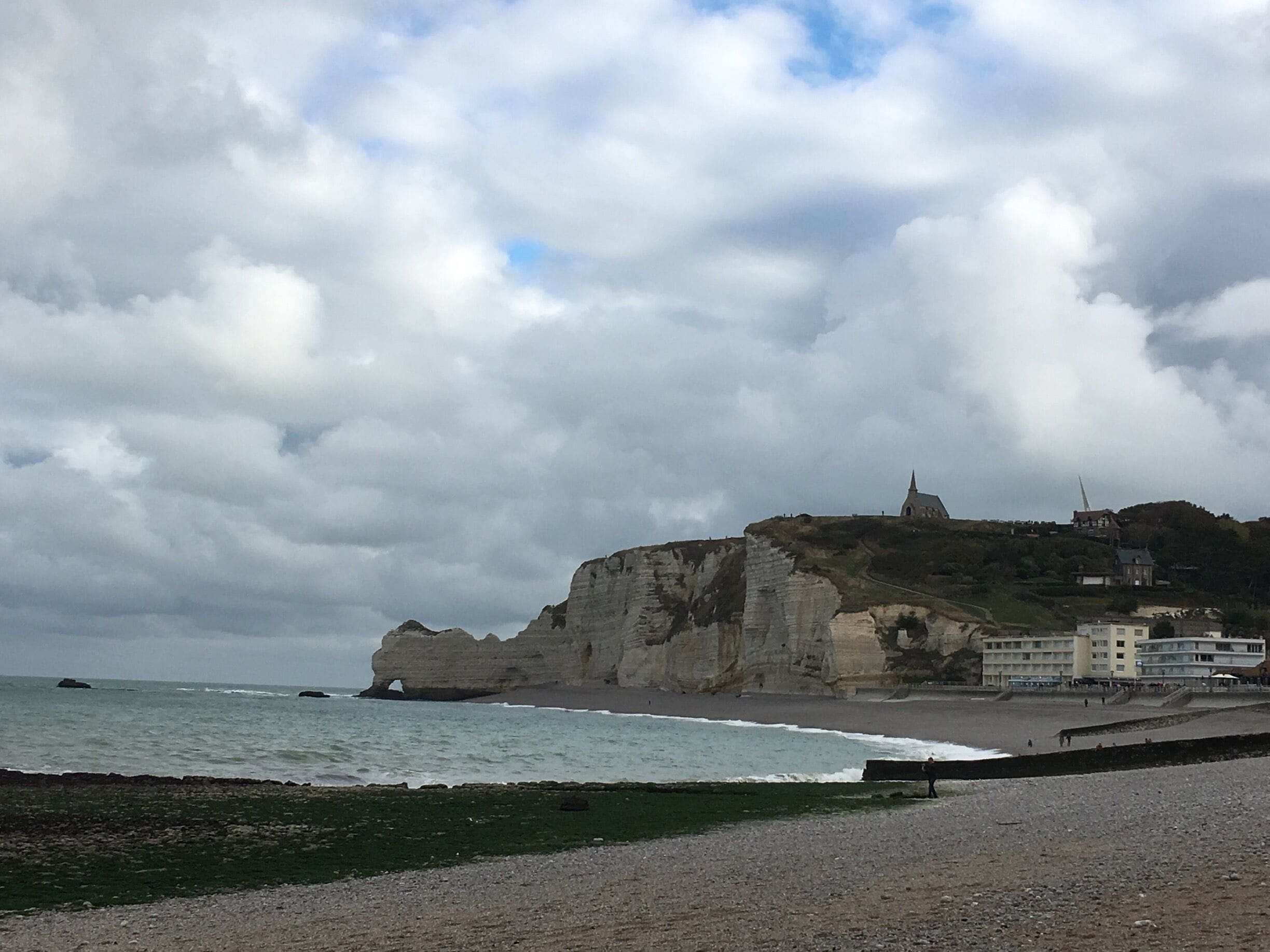 The beach of Etretat with the cliffs and on top the Chapelle Notre dame de la garde. If you have time climb the cliffs!! 