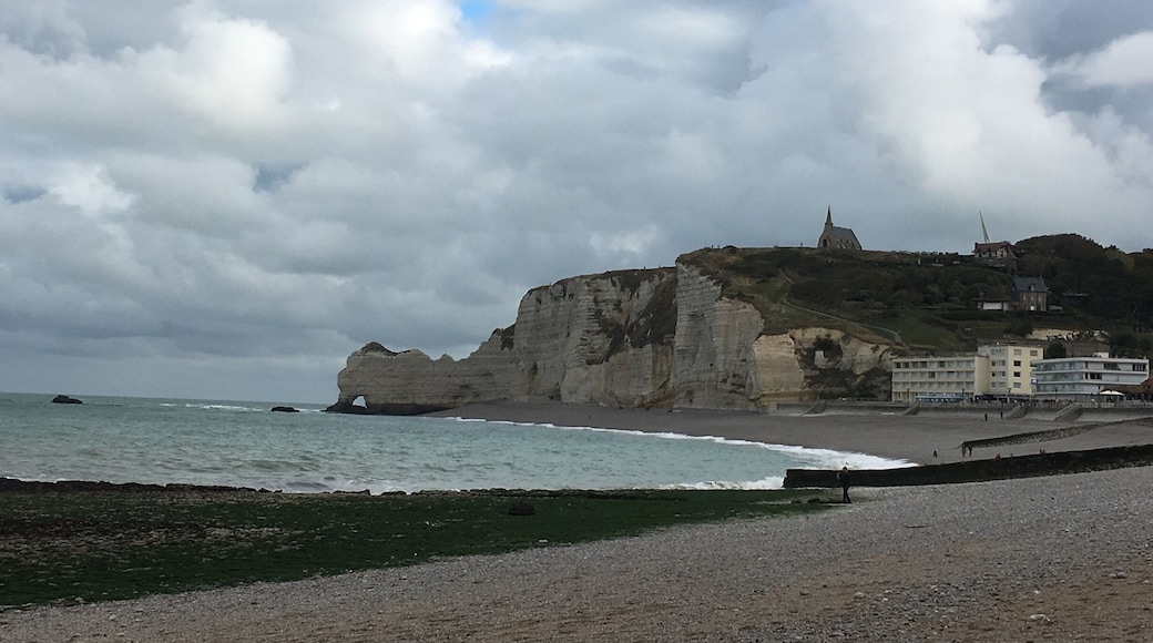 The beach of Etretat with the cliffs and on top the Chapelle Notre dame de la garde. If you have time climb the cliffs!!