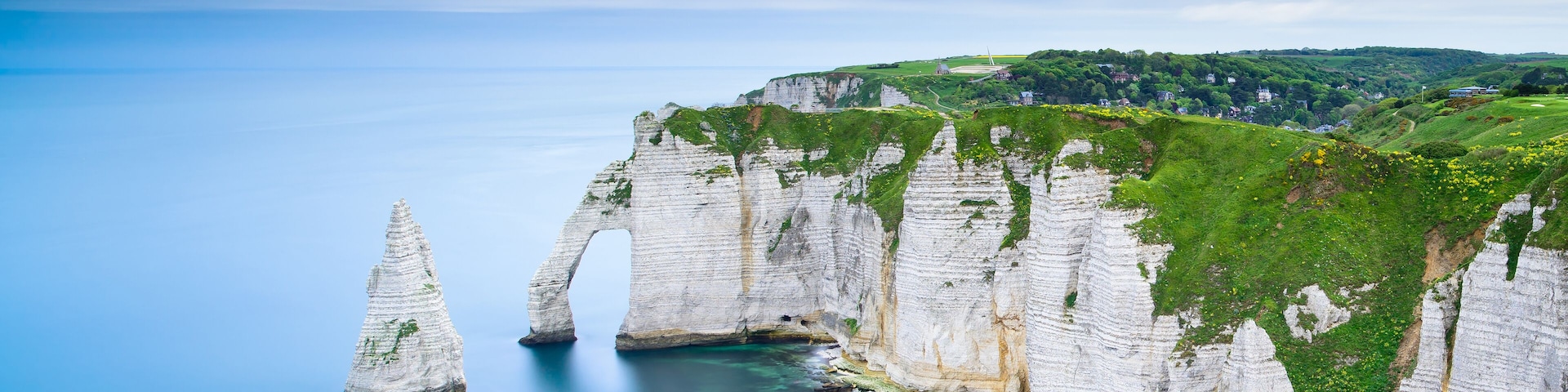 Etretat Aval cliff, rocks and natural arch landmark and blue ocean. Aerial view. Normandy, France, Europe