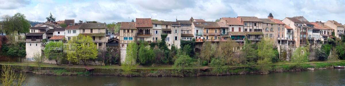 Eine Flussstadt mit historischen Gebäuden und einer Brücke.