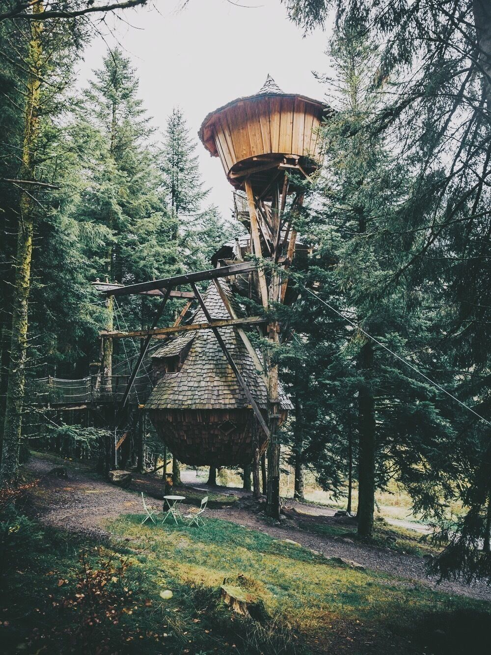 A rustic wooden structure with a water tower in a forested area.