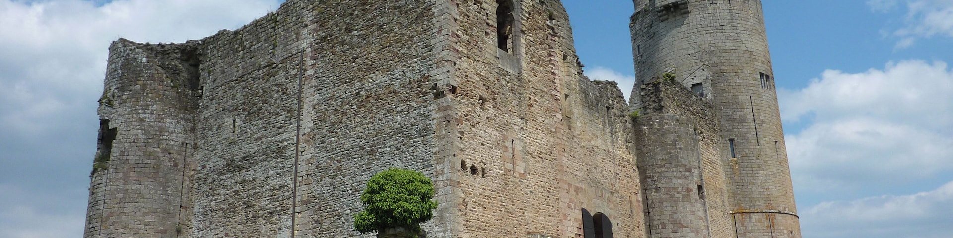 A large, historic stone castle with a prominent tower and a narrow passageway.