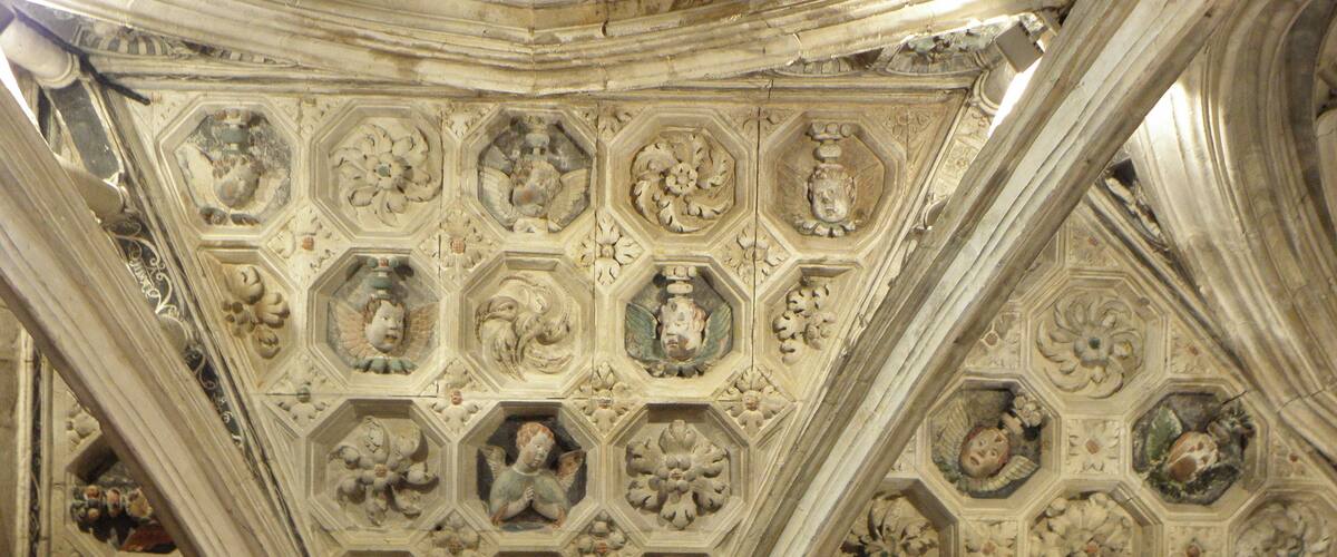 A detailed ceiling with hexagonal patterns and various sculptural elements.