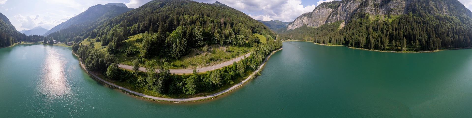 360 degrees panorama of Lac Montriond seen from above. Aerial of French Alps mountain range melt water lake in summer.
