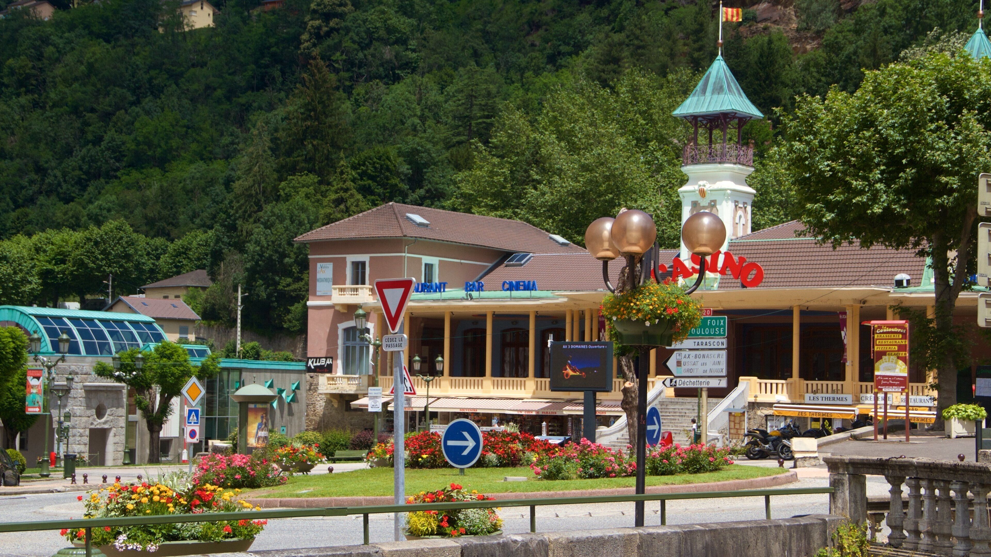 A town square with a casino, a bar, and a cinema. There are flower beds and a traffic sign.