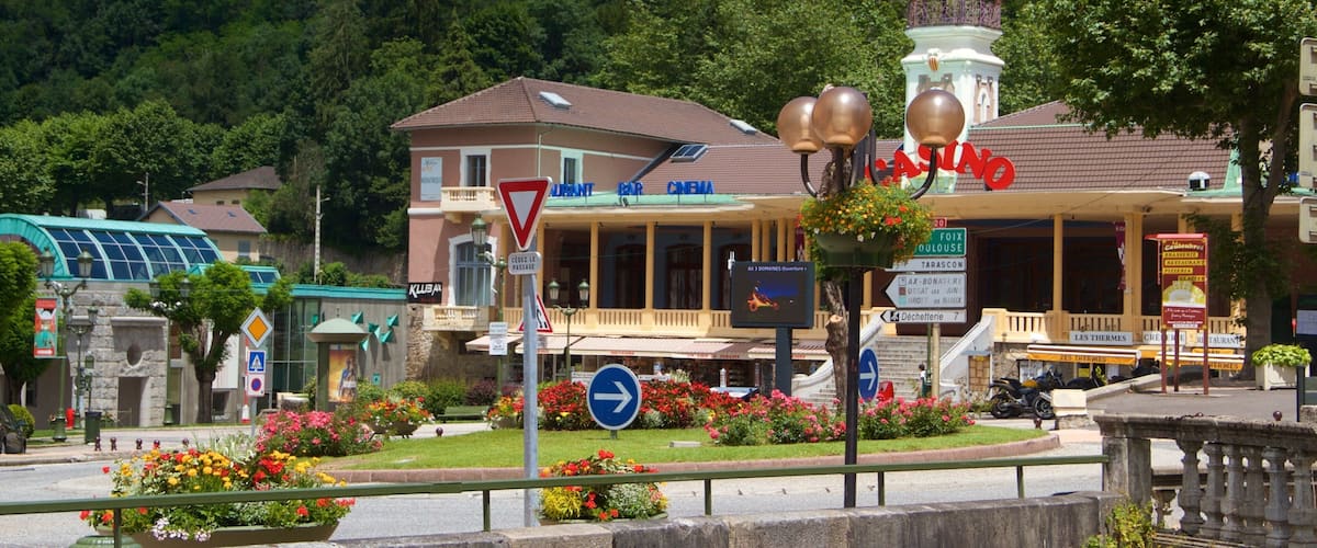 A town square with a casino, a bar, and a cinema. There are flower beds and a traffic sign.