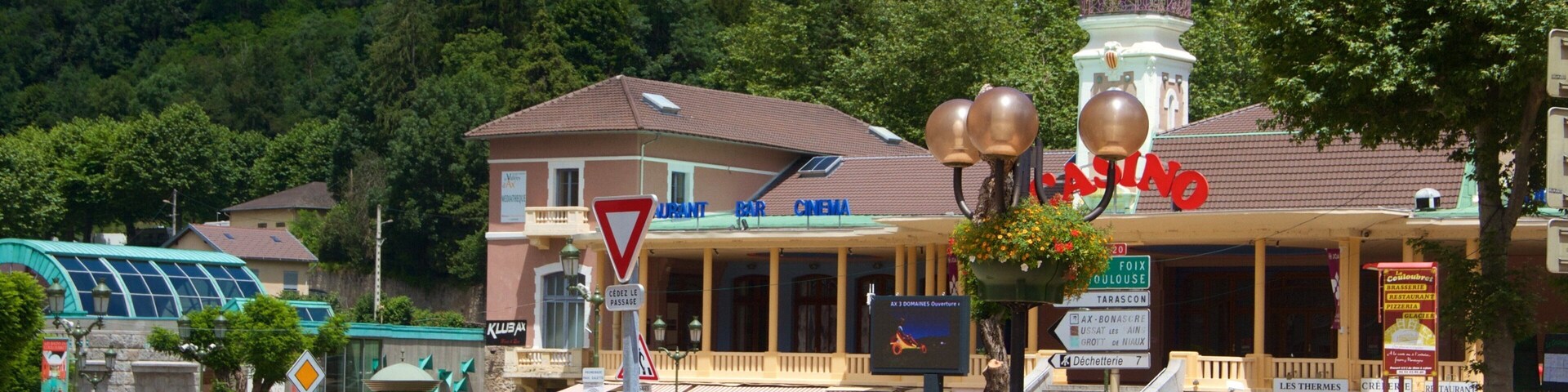 A town square with a casino, a bar, and a cinema. There are flower beds and a traffic sign.