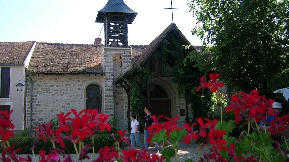 A church with a bell tower and a cross on top.