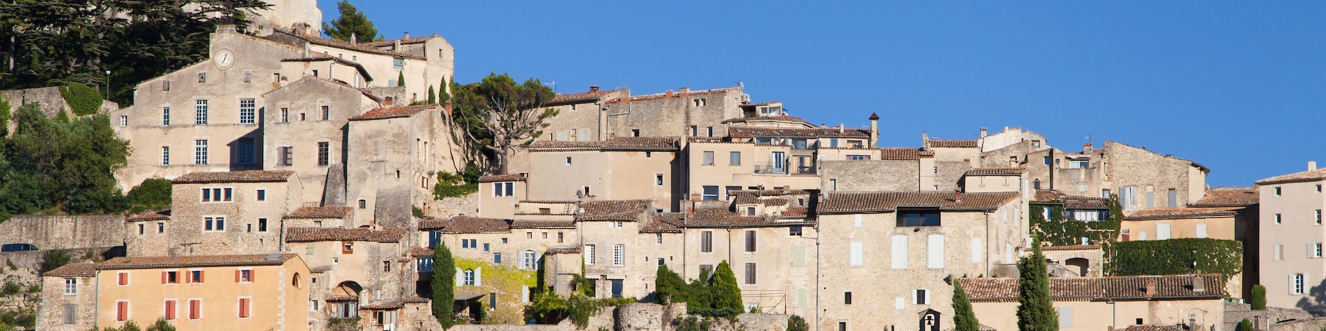 A historic town with a prominent church tower, terraced buildings, and lush greenery.