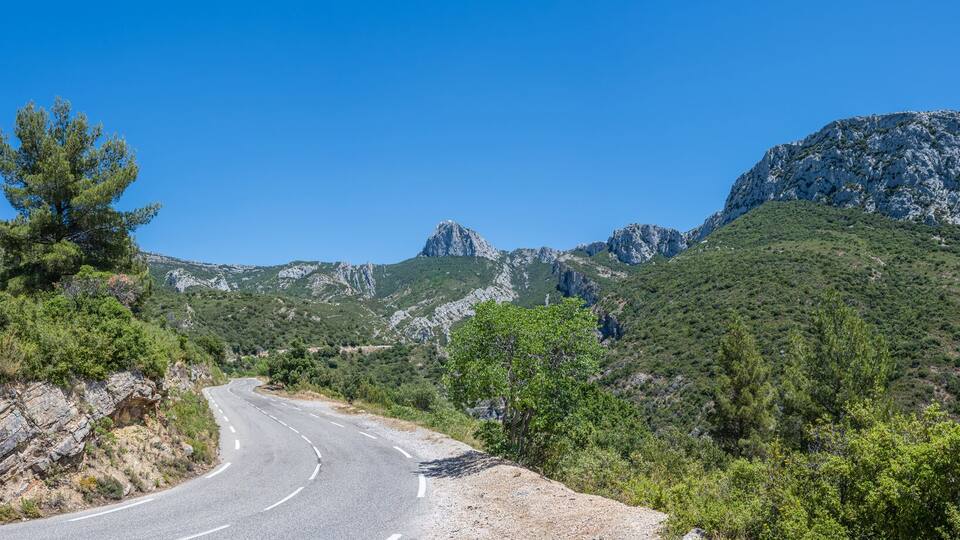 Curved mountain road and panorama view of the landscape around "vallon st pons" near Gemenos in the Bouches-du-Rhône department, Provence-Alpes-Côte d’Azur. "Pic de Bertagne" visible in background.