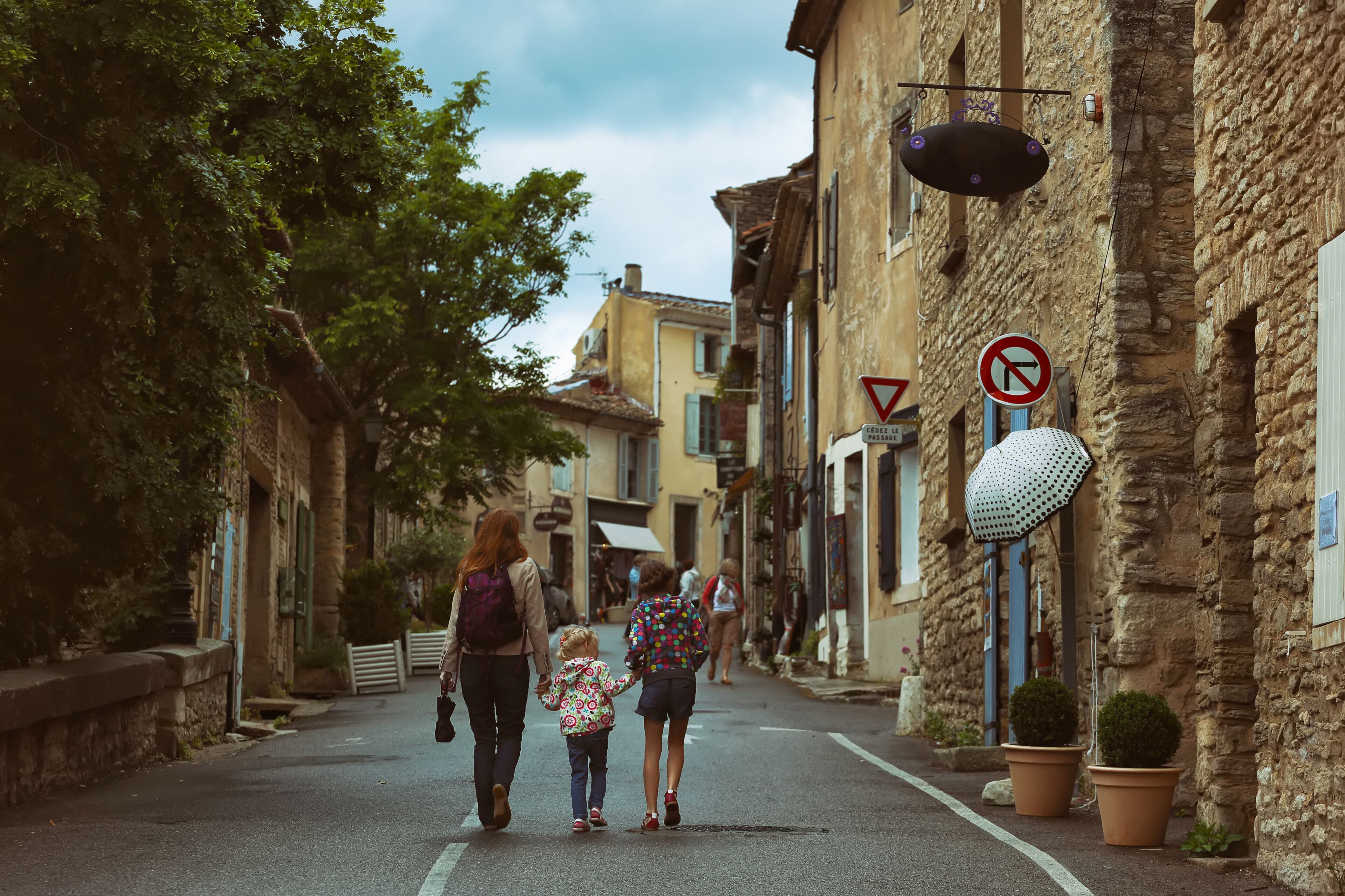 A narrow street lined with stone buildings, a no right turn sign, and a pedestrian crossing.