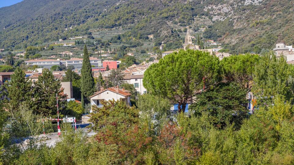 A mountainous town with buildings, trees, and a prominent church.