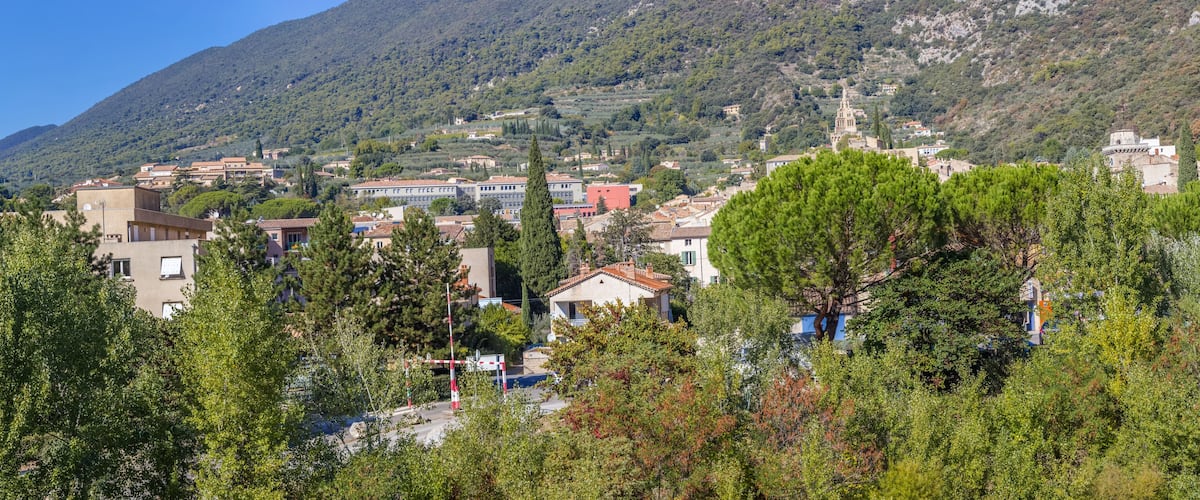 A mountainous town with buildings, trees, and a prominent church.