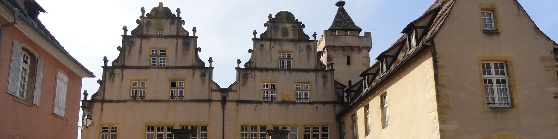 A historic building with a central tower, a courtyard, and a traditional facade.