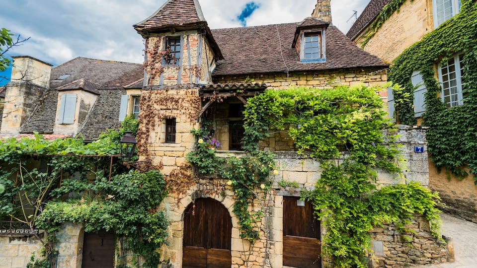 A historic stone building with ivy-covered walls and a tower.