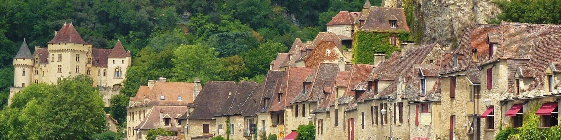 Une ville riveraine dotée de bâtiments historiques, d’un château et d’une falaise abrupte.