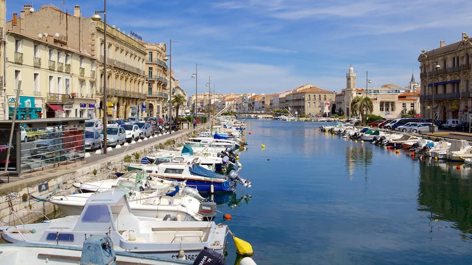 A marina with boats docked along a waterfront, surrounded by historic buildings and a clear sky.