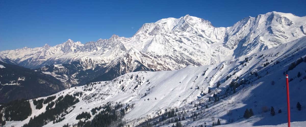 A snow-covered mountain range with a clear blue sky.