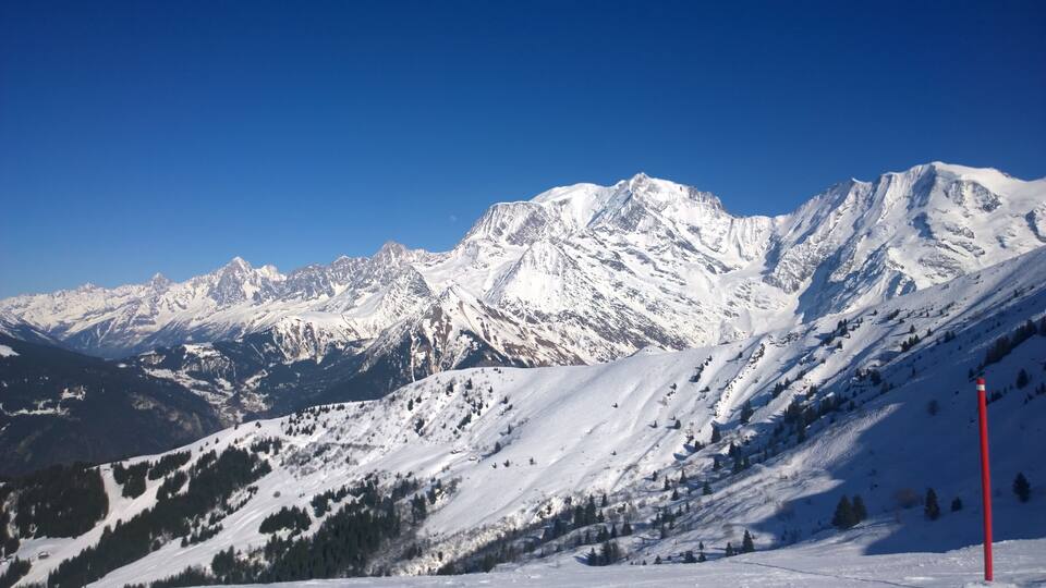 A snow-covered mountain range with a clear blue sky.