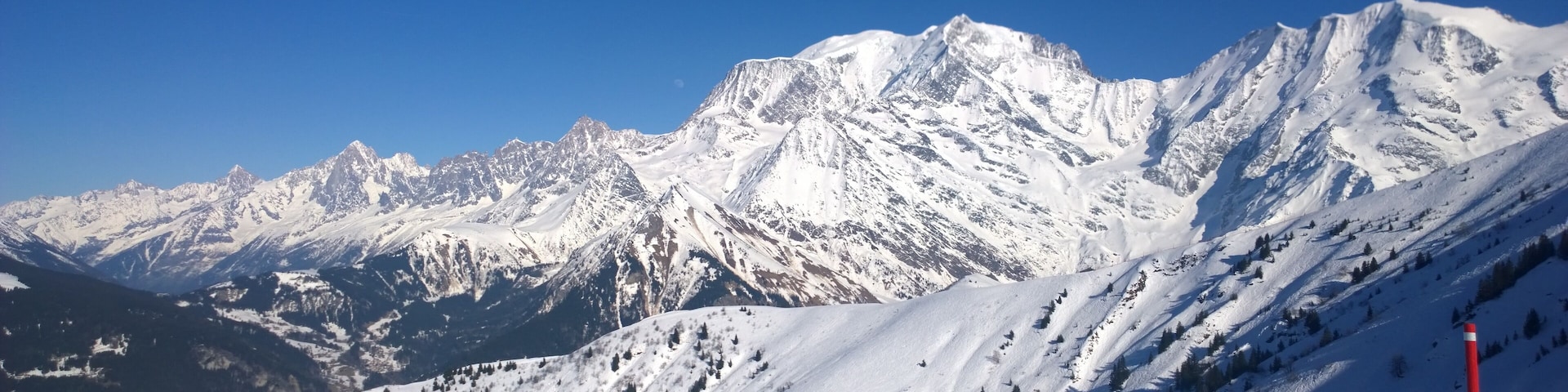 A snow-covered mountain range with a clear blue sky.