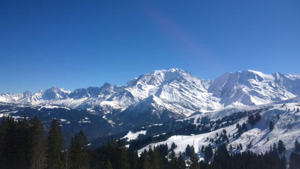 A snow-covered mountain range with clear blue skies.