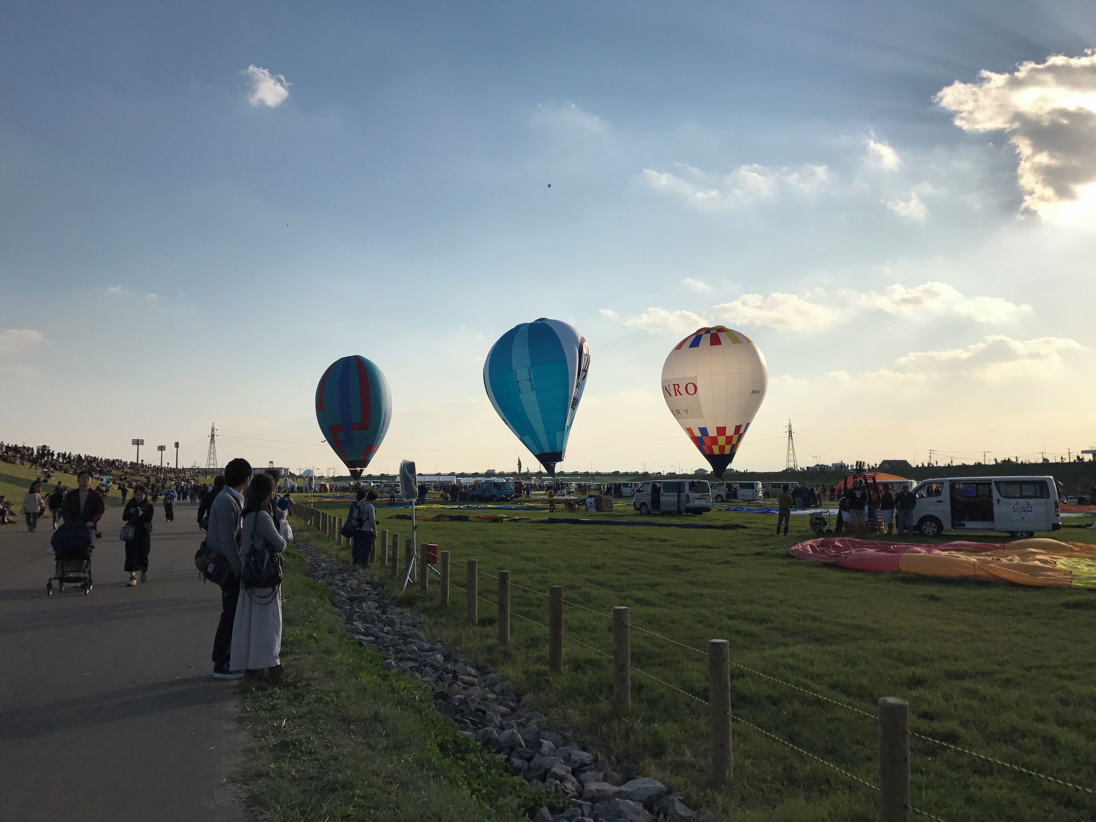 A hot air balloon festival with three balloons in the sky.
