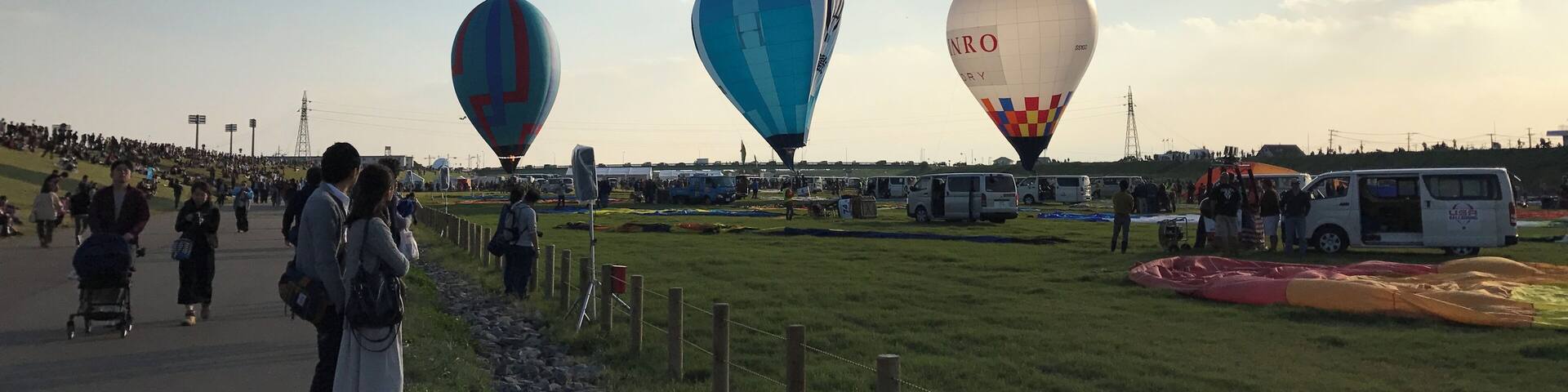 A hot air balloon festival with three balloons in the sky.