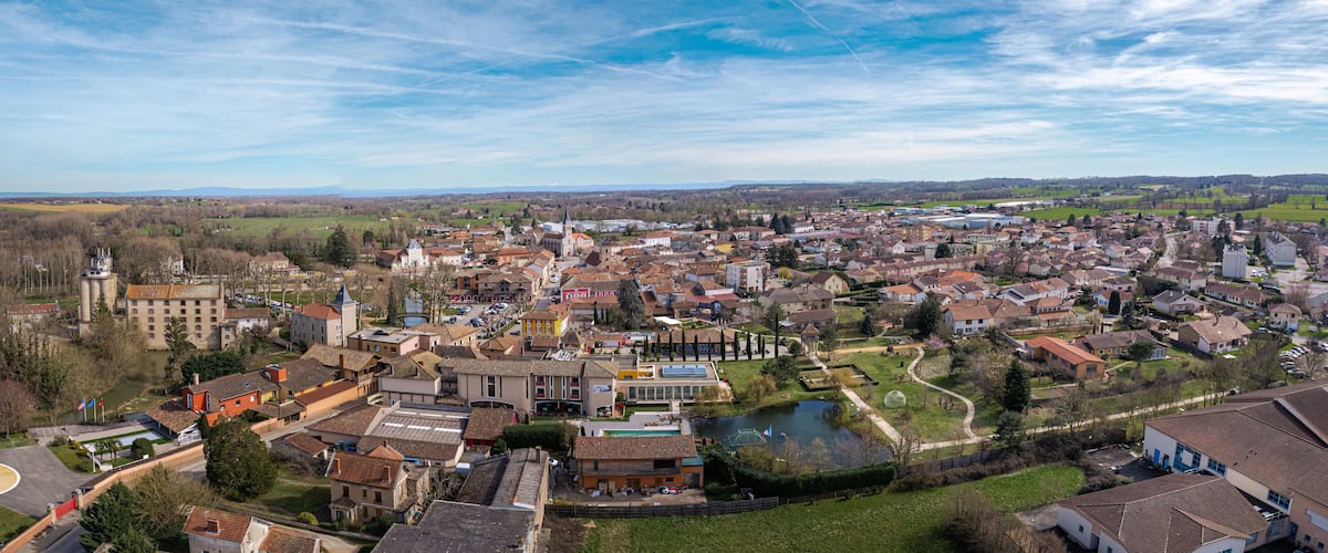 A town with a prominent church, a river, and surrounding fields.