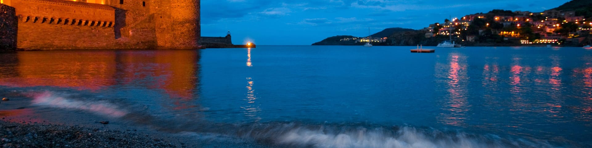 Surf on the beach near the entrance to the harbor of Collioure, France; Collioure, Pyrenees Orientales, France