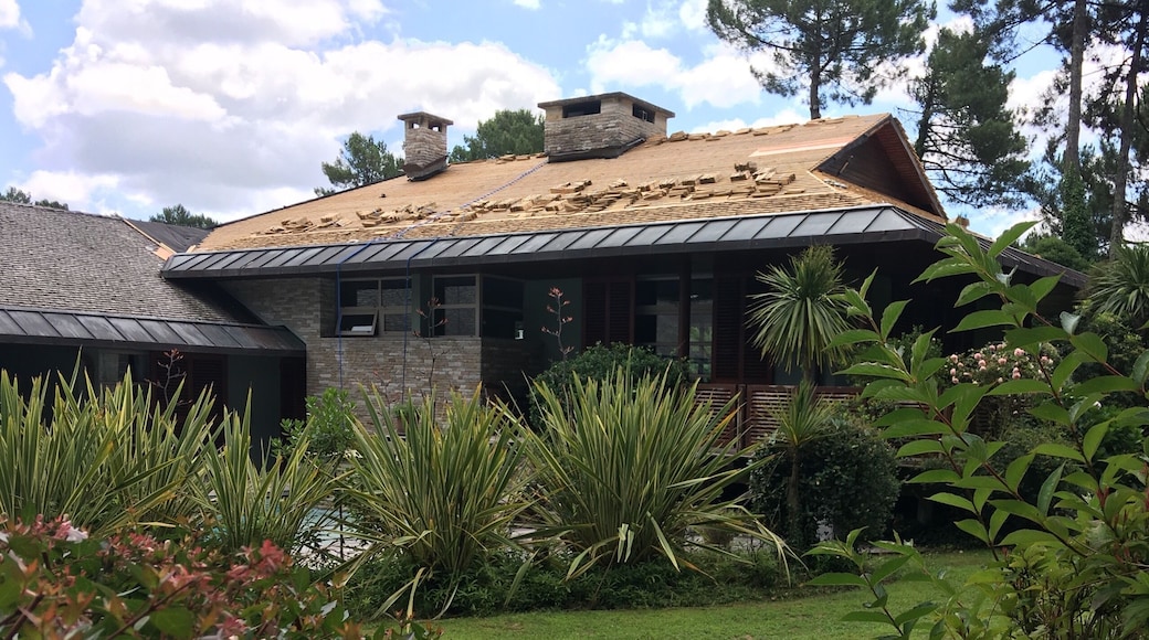 Wood shingles being laid on a roof with a low incline on a mansion in Seignosse, Aquitaine, France