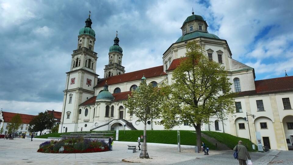 A historic church with two green domes and a clock tower.