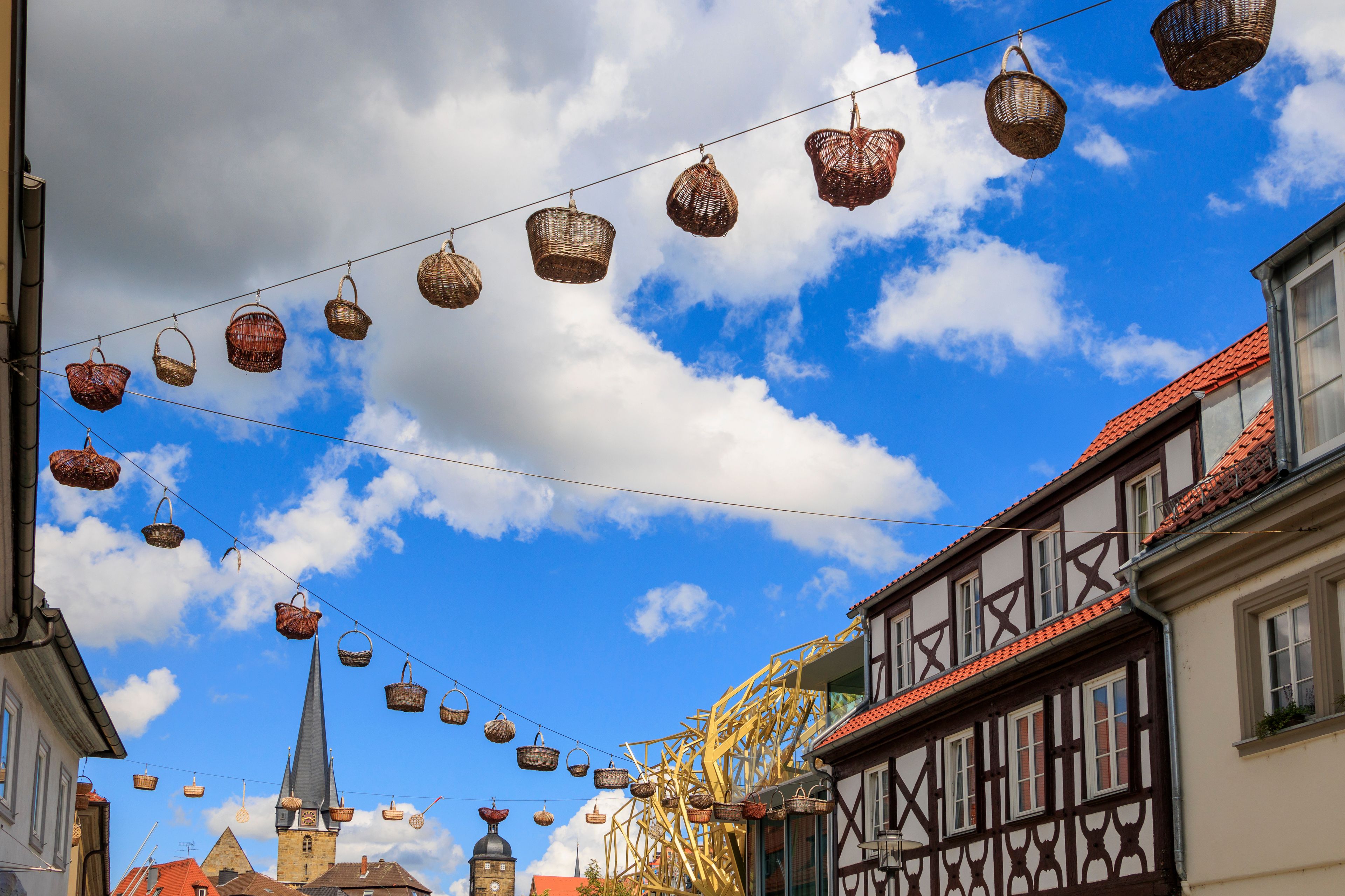 A street with traditional half-timbered houses and a church with a spire.