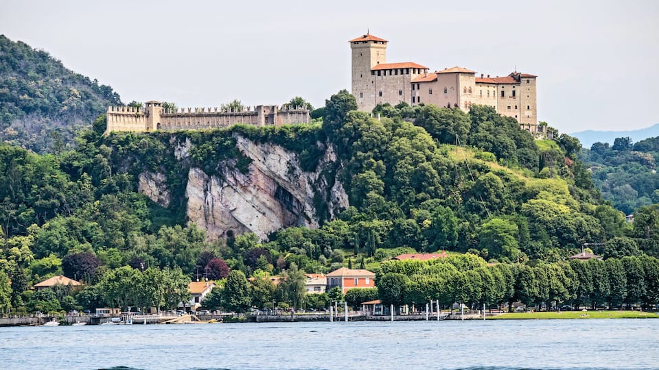 A castle on a cliff by a lake.