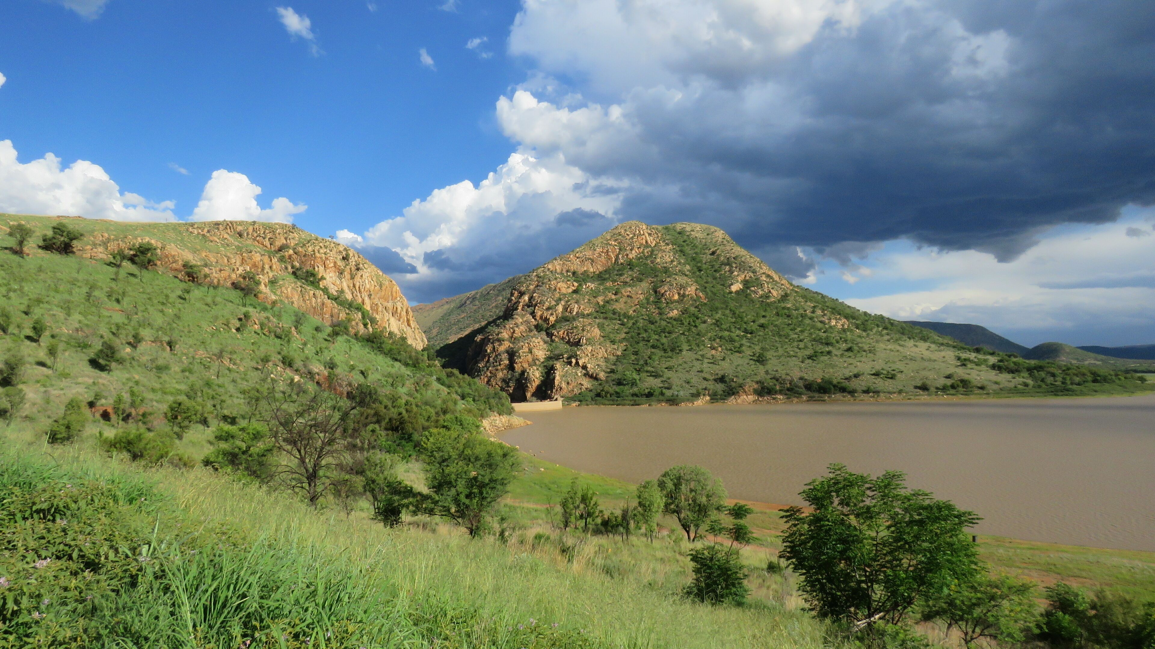 A river valley with hills and a cloudy sky.