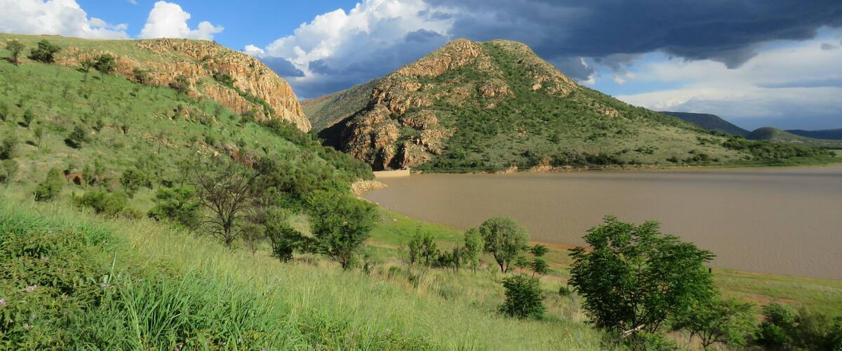 A river valley with hills and a cloudy sky.