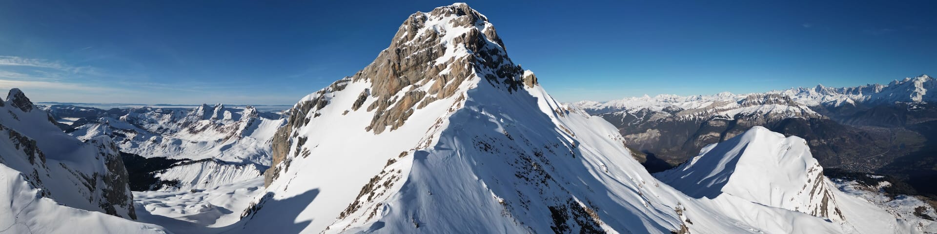 A snow-covered mountain peak with a clear sky.
