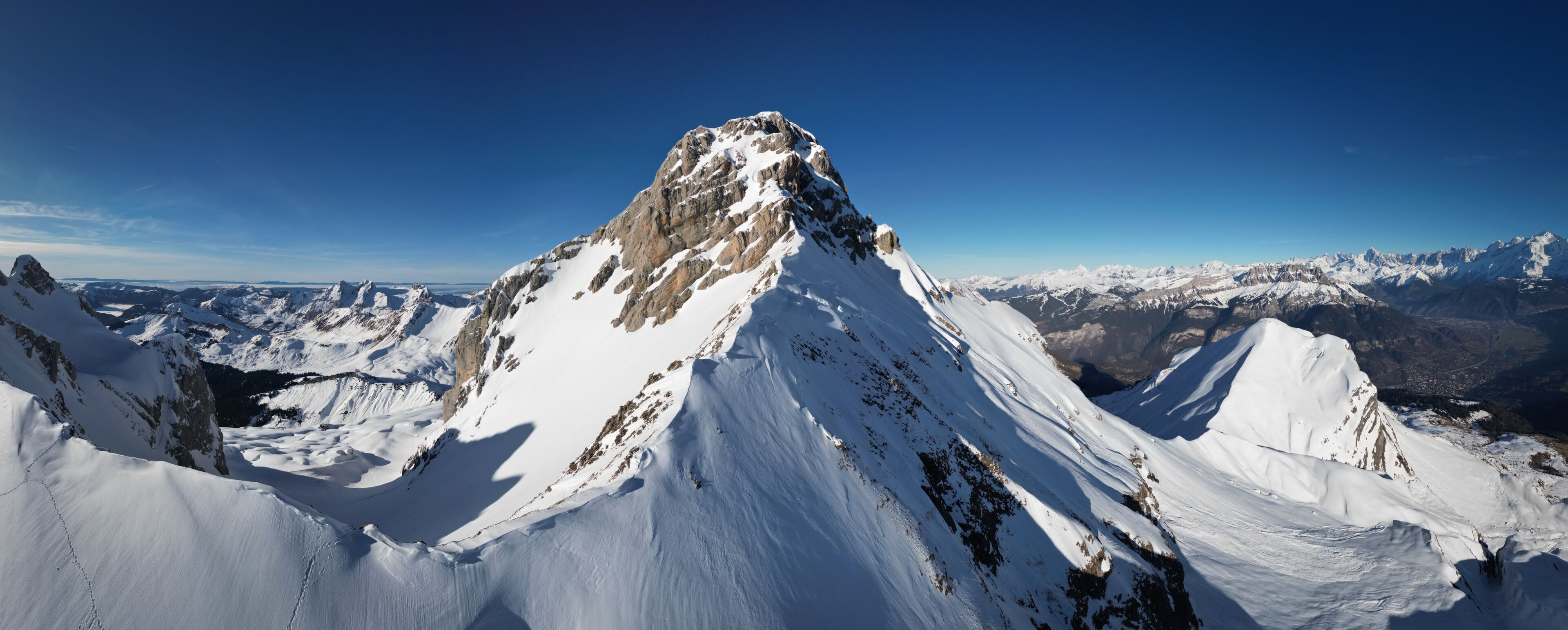 A snow-covered mountain peak with a clear sky.
