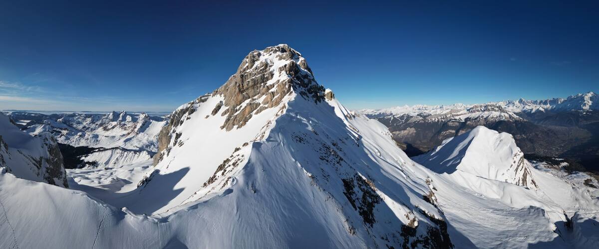 A snow-covered mountain peak with a clear sky.