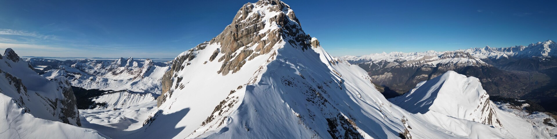 A snow-covered mountain peak with a clear sky.