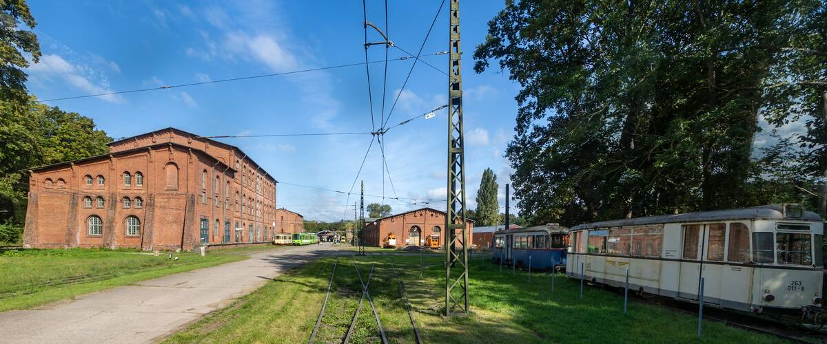A railway track with old trains and a brick building.