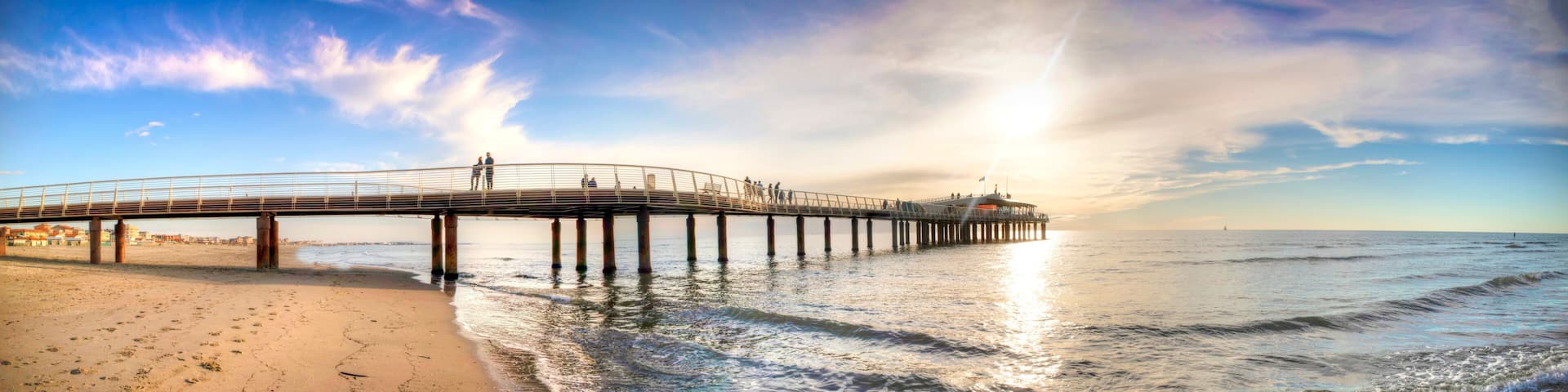 A pier extending into the ocean with people walking along it.