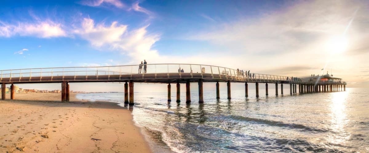 A pier extending into the ocean with people walking along it.
