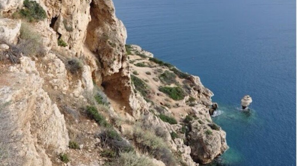 Cliff with caves at Melagavi Lighthouse overlooking Gulf of Corinth.