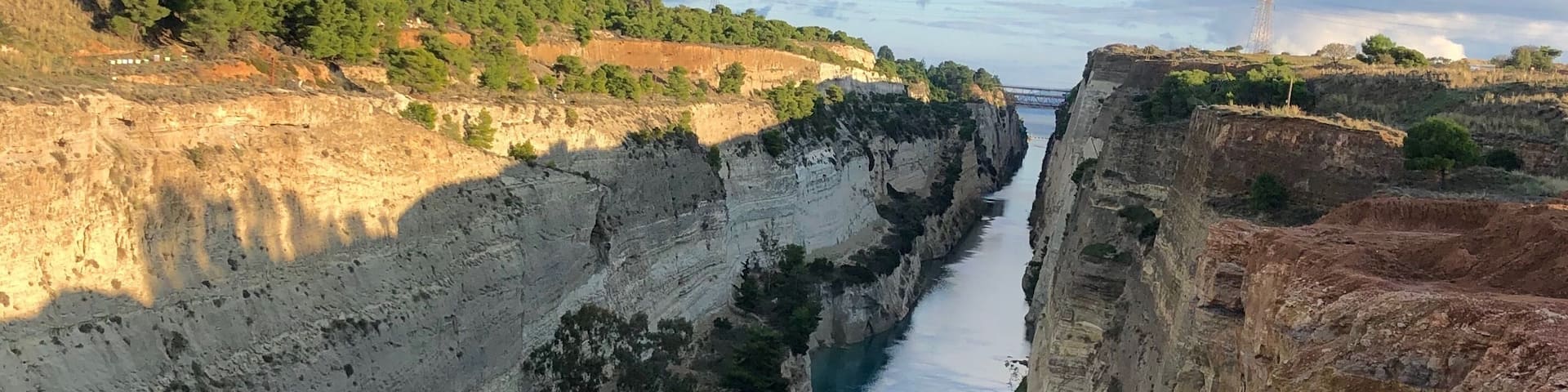 A canyon with a river running through it, surrounded by cliffs and sparse vegetation.