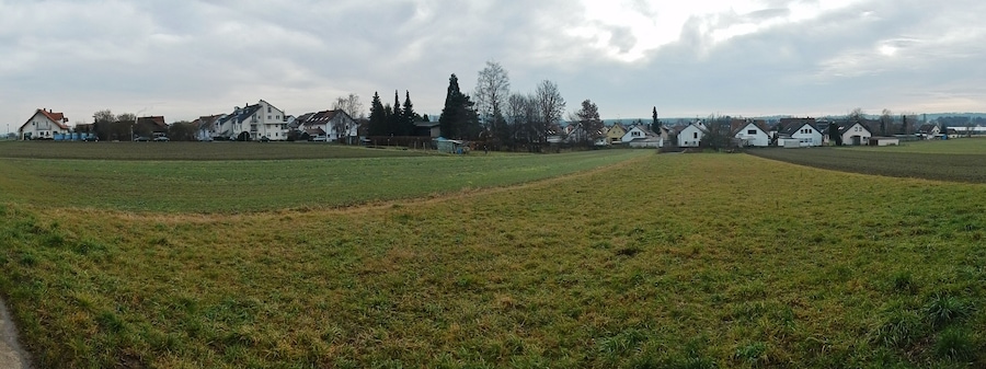 Paisaje rural con campos, casas y árboles.