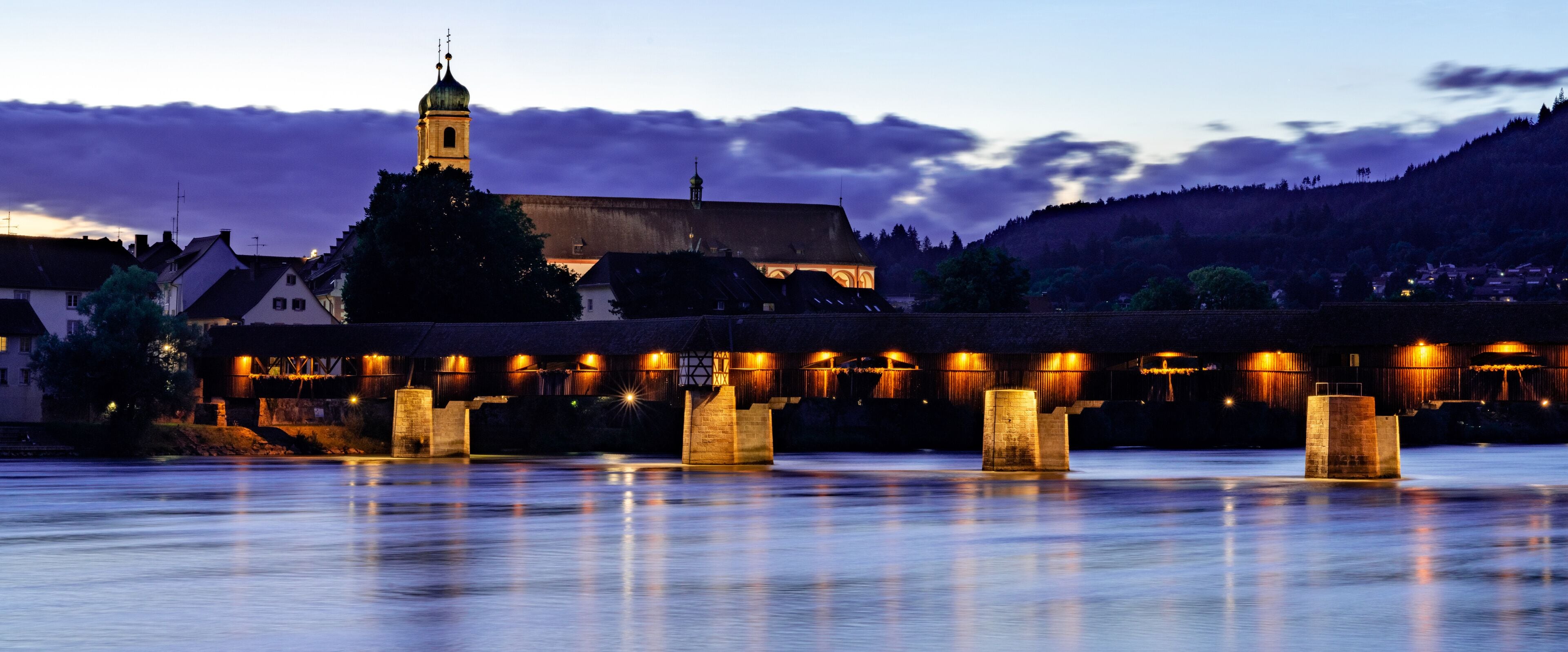 view of the St. Fridolin cathedral and Rhine bridge in Bad Saeckingen at sunset